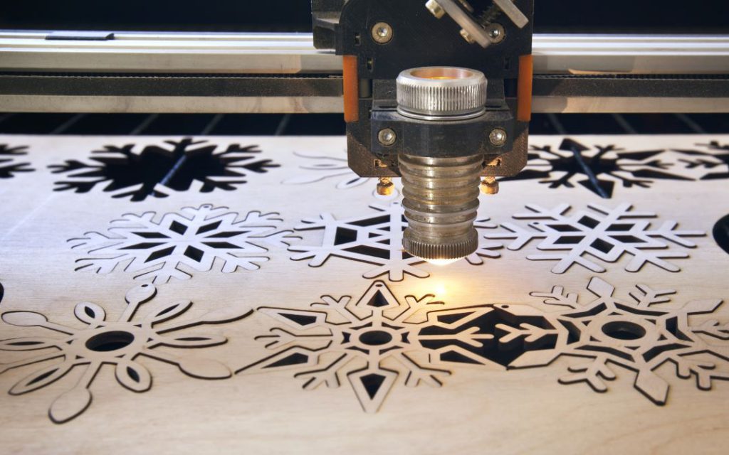 Image of laser machine cutting shapes out of wood