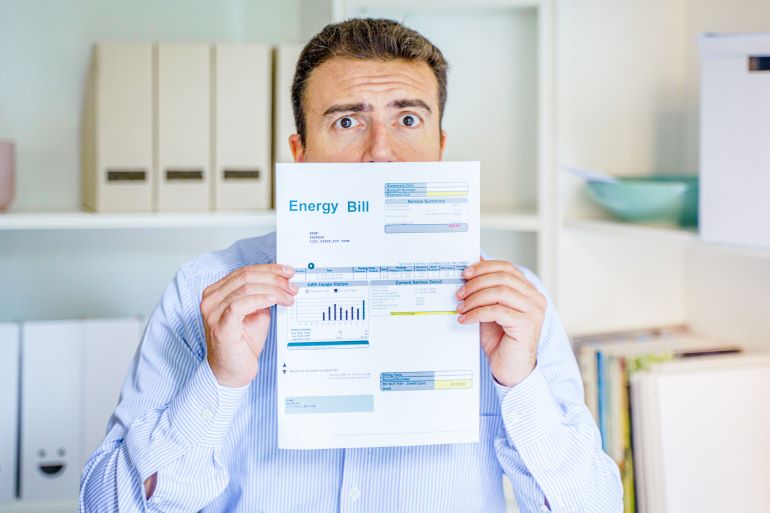 Worried Business Manager holding up energy bill